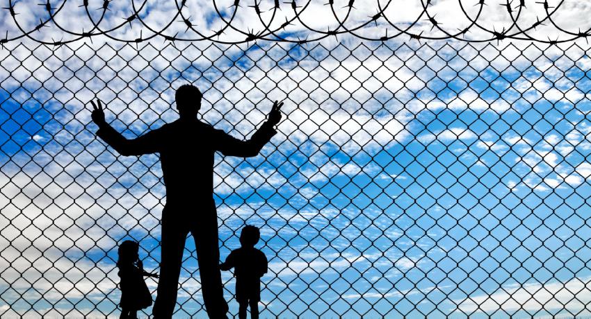adult in prison with children near fence