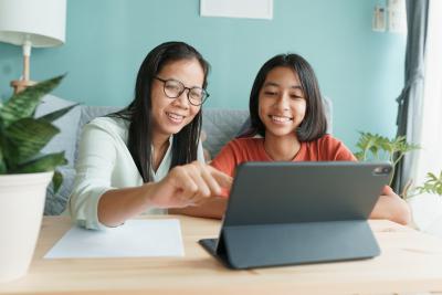 adult woman and youth on computer