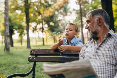 Little boy blowing bubbles in the park