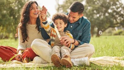 Adults with child in a field blowing bubbles