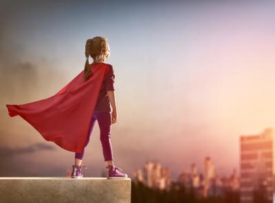 Girl stading on roof with red superhero cape