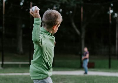 Kids throwing baseball to a person who is far way