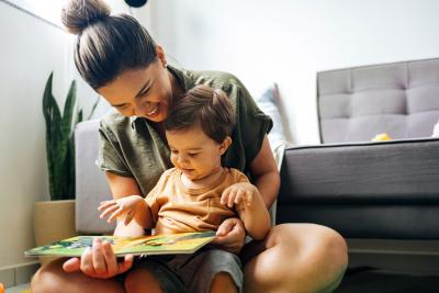 Young woman reading book with a toddlers.