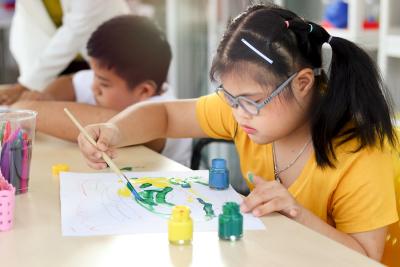 Children at a table painting.