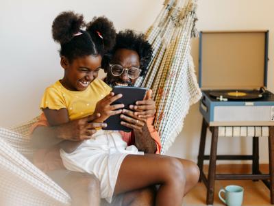 Woman and young adult looking at a photo.