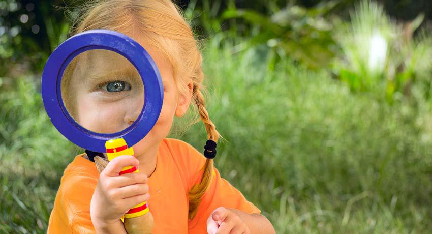 Young girl with magnifying glass