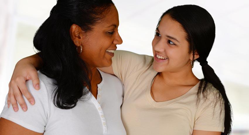 Teenage girl with arm around adult woman