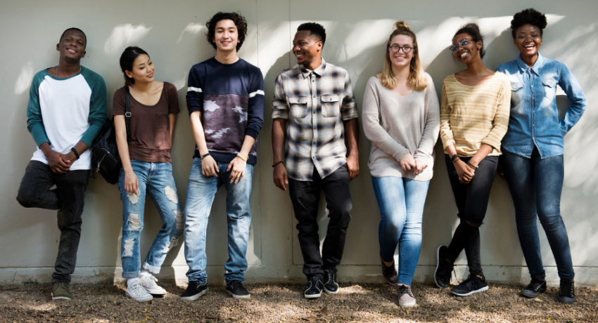 Group of teenage kids hanging out against a wall