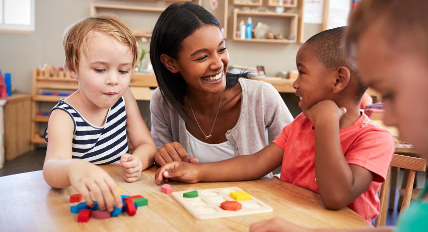 Child care teacher with children playing with a puzzle