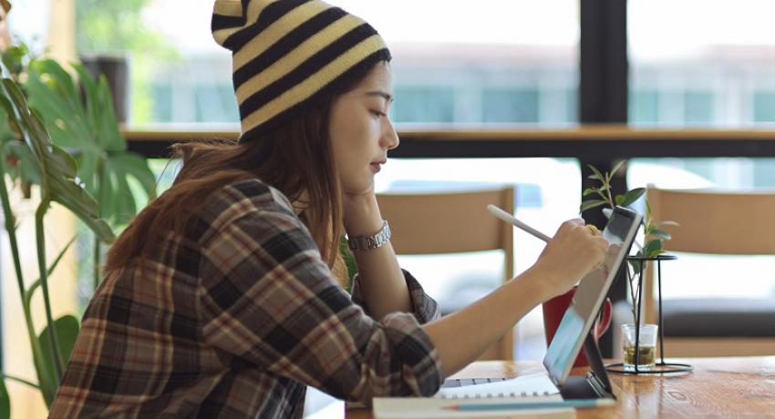 Young woman using her laptop at a desk. 