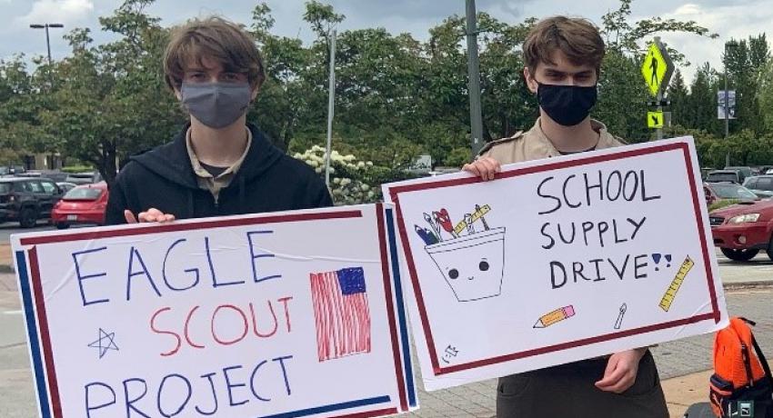 Eagle Scouts holding donation signs