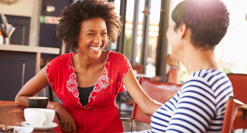 Two adults talking over coffee. 