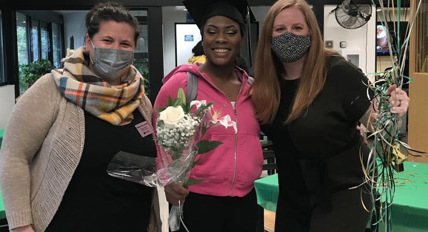 Echo Glen staff with graduating youth holding balloons and flowers. 