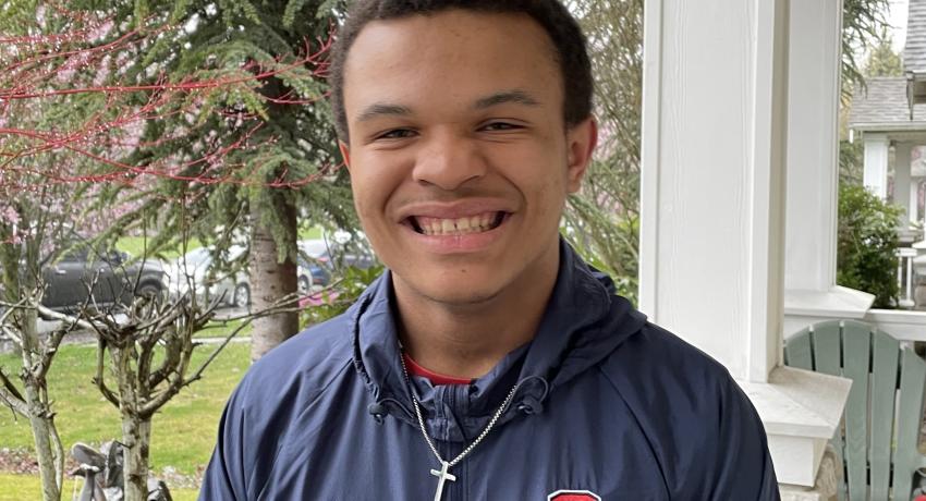teenage boy standing outside and smiling at the camera 